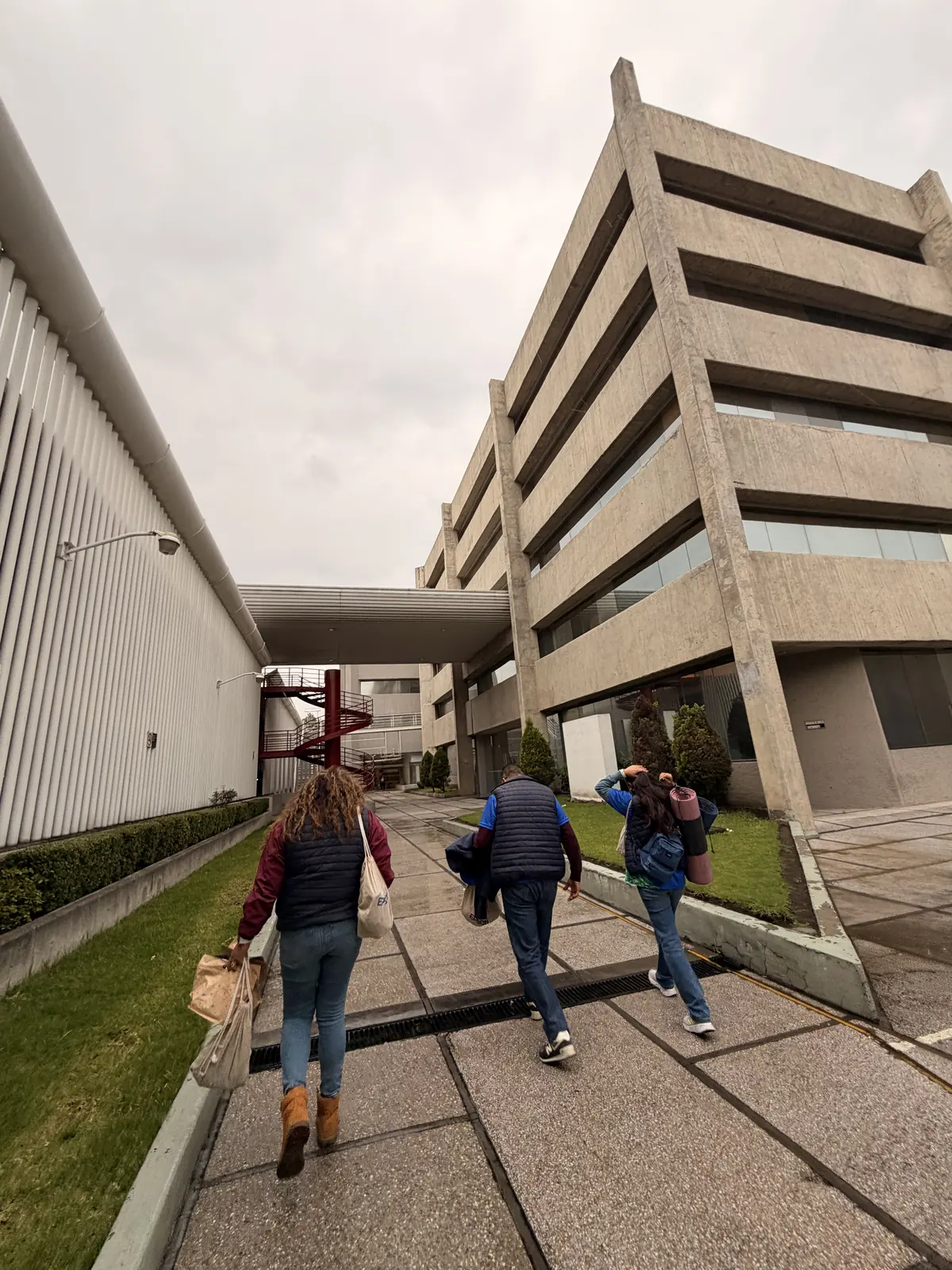 Integrantes del equipo de Epson Empresas caminan con mochilas por el pasillo exterior del corporativo, antes de salir hacia el Nevado de Toluca