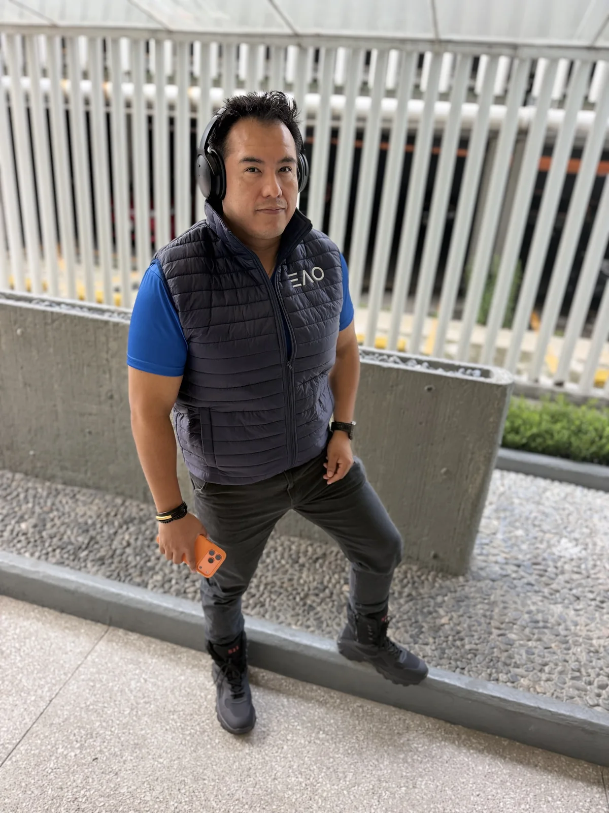 Integrante del equipo de Epson Empresas de pie junto a un muro de concreto en el corporativo, listo para salir hacia el Nevado de Toluca